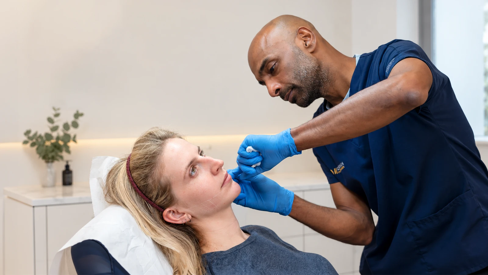 Dr Suresh Mohan assessing a patient's jaw and masseter muscle during treatment in Wimbledon