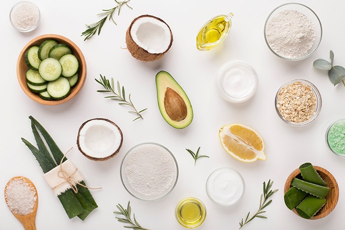 Array of skincare products and natural nutrients like avocado and aloe vera, showcasing essential elements for skin nourishment post-Profhilo treatment