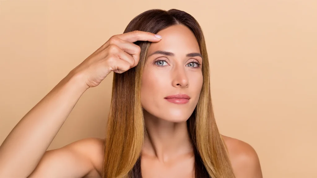 Woman with natural facial expression showing subtle frown lines between the eyebrows.